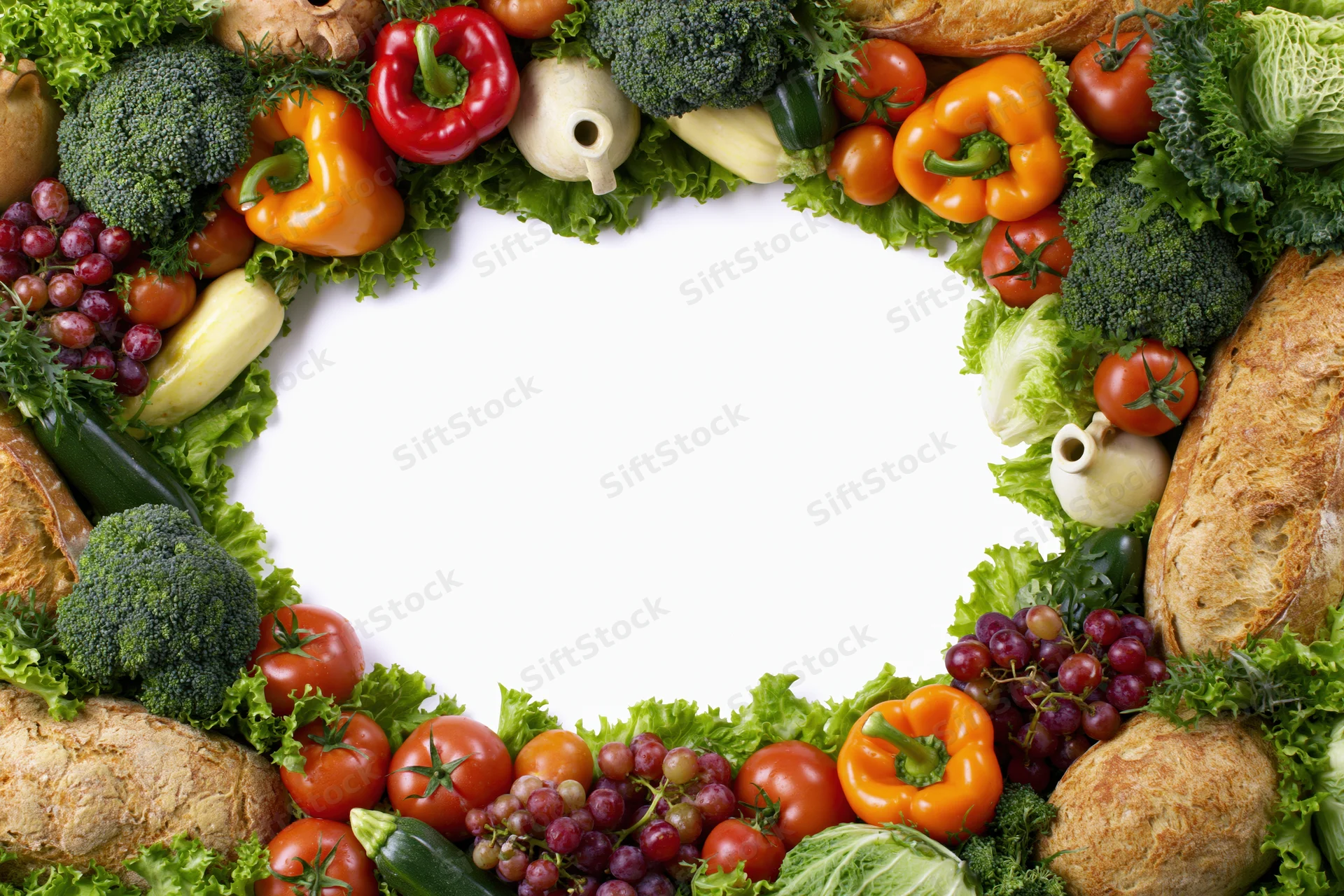 Heart-shaped frame of fresh vegetables and fruits arranged on white background