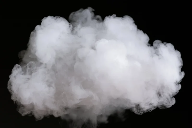 Dense white smoke cloud billowing against black background