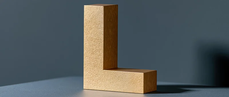 Large three-dimensional gold letter l on a gray surface with soft shadow and copyspace