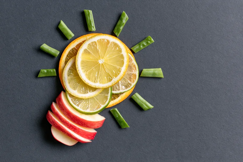 Citrus fruit slices arranged in lightbulb shape on dark surface