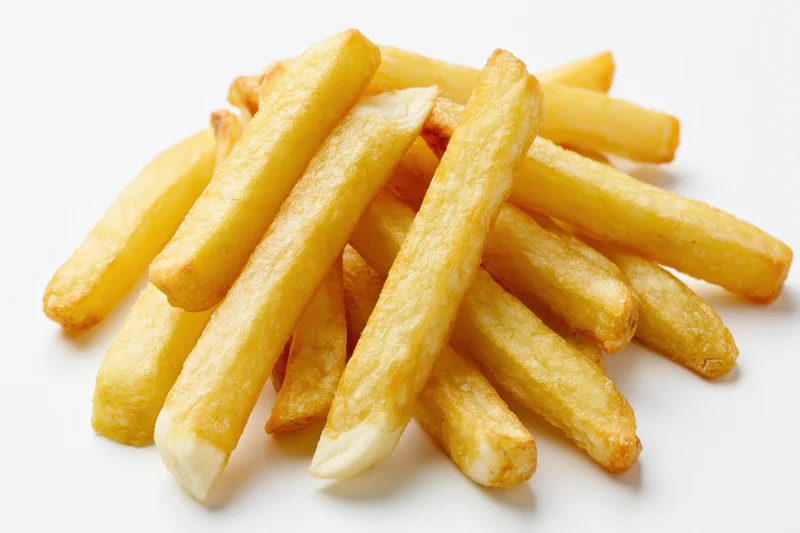 Pile of golden french fries on white background