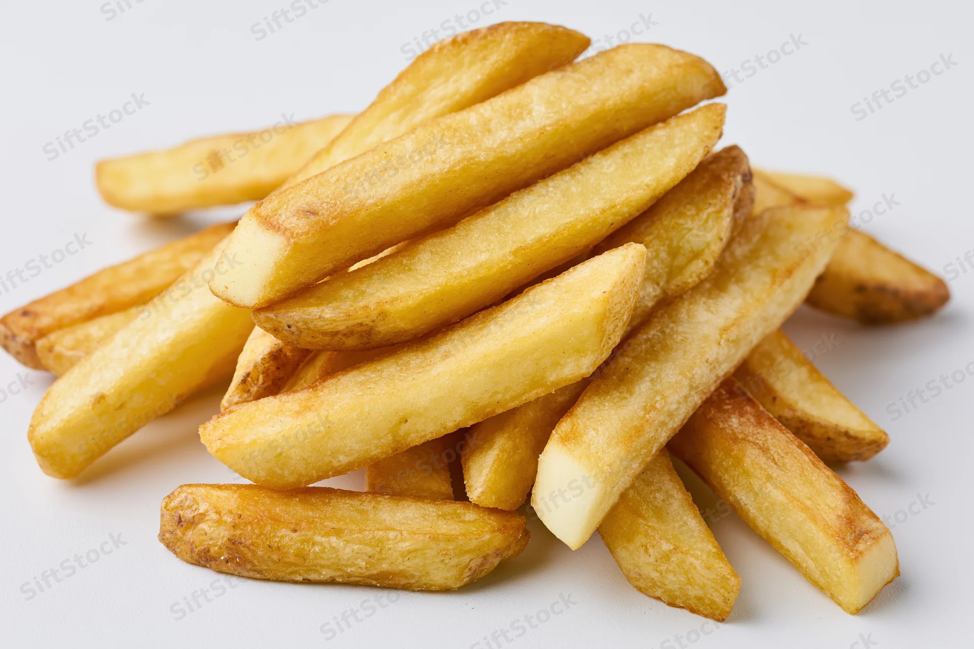 Golden french fries piled casually on a white surface