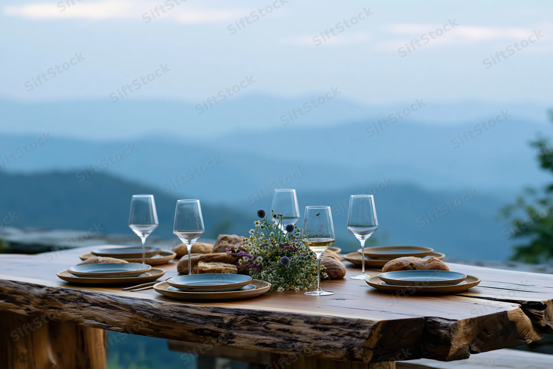 Rustic wooden dining table set for dinner outdoors with mountain view