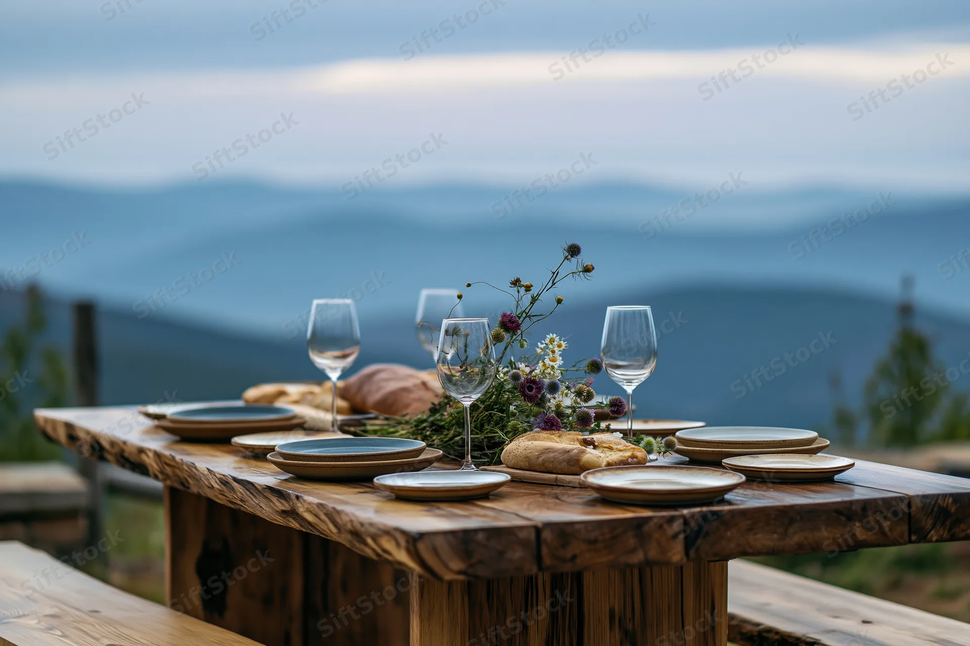Rustic wooden dining table set for dinner outdoors with mountain view