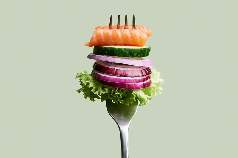 Silver fork holding stacked salmon, cucumber, red onion, and lettuce against light green background