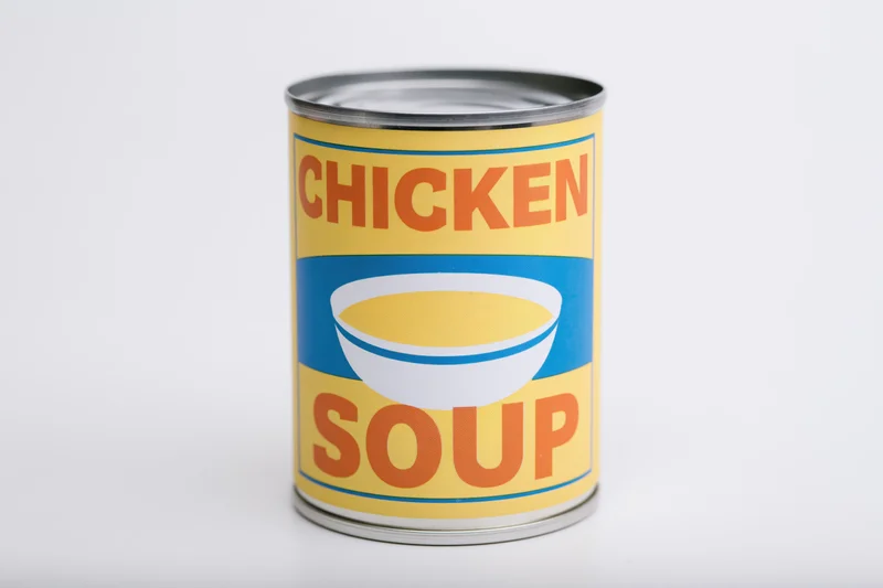 Single tin can of chicken soup with colorful label standing upright on white background