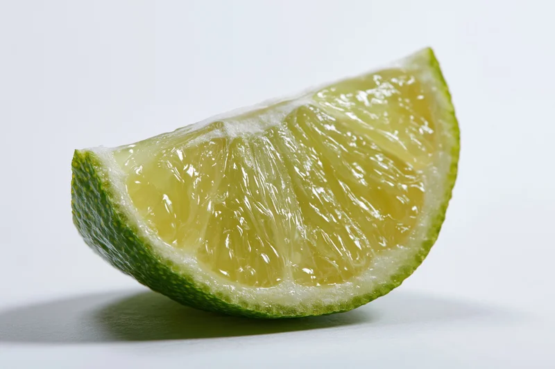 Lime wedge slice cut side forward on white background