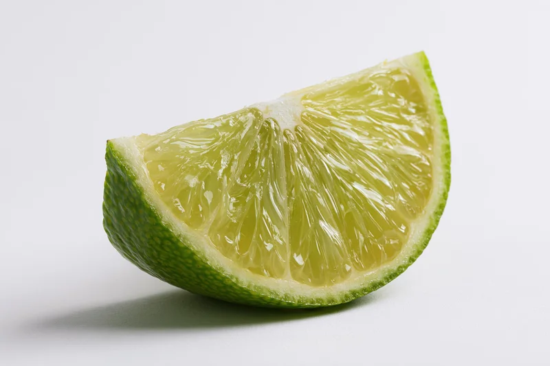 Lime wedge slice cut side forward on white background