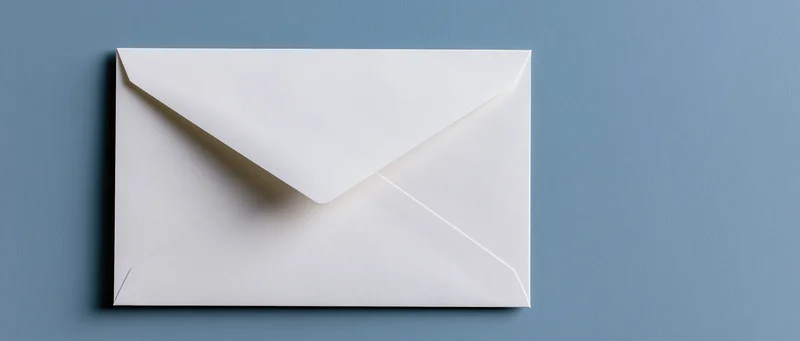 White paper envelope closed and centered on a blue textured surface