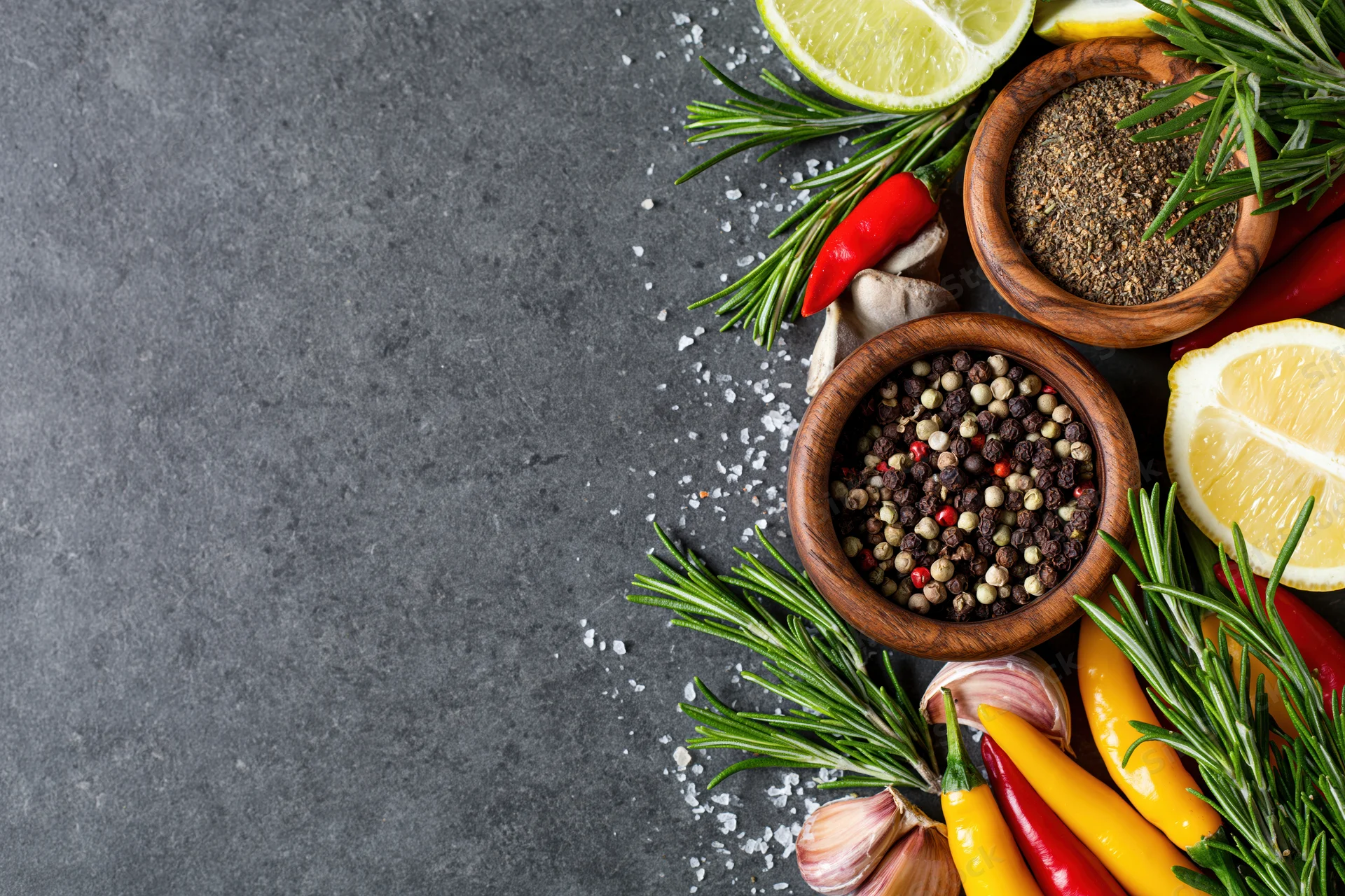 Fresh herbs and spices arranged along the right edge of a gray countertop