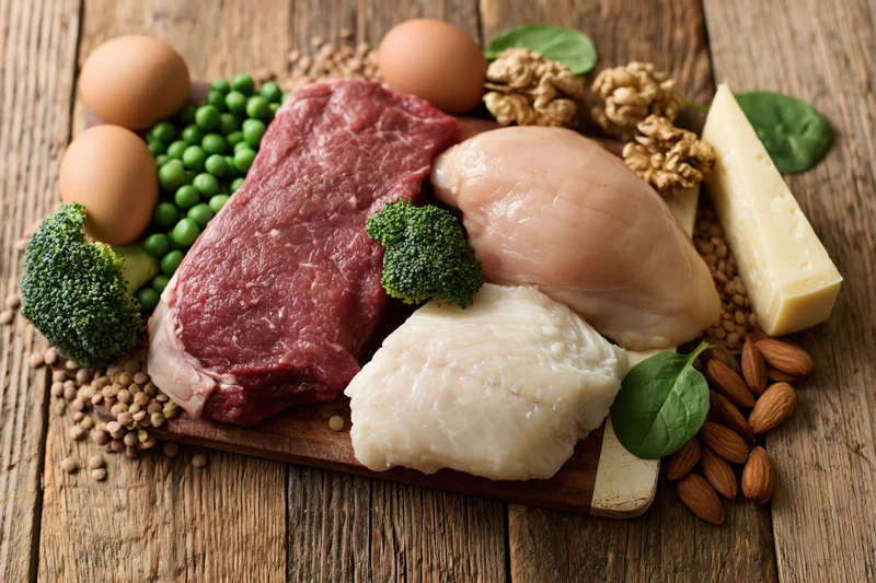 Assorted high-protein foods arranged on a rustic wooden table