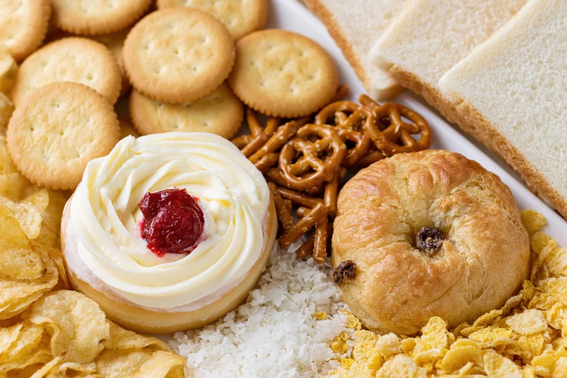 Assorted processed snack foods arranged together in a flat lay on a white surface