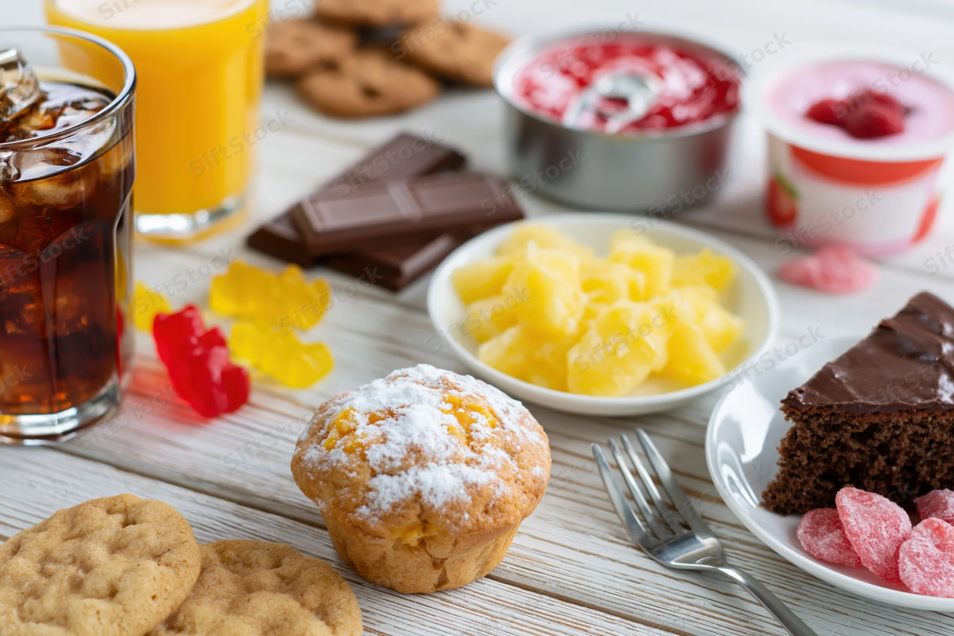 Assorted sugary foods and drinks arranged on a white painted wooden table