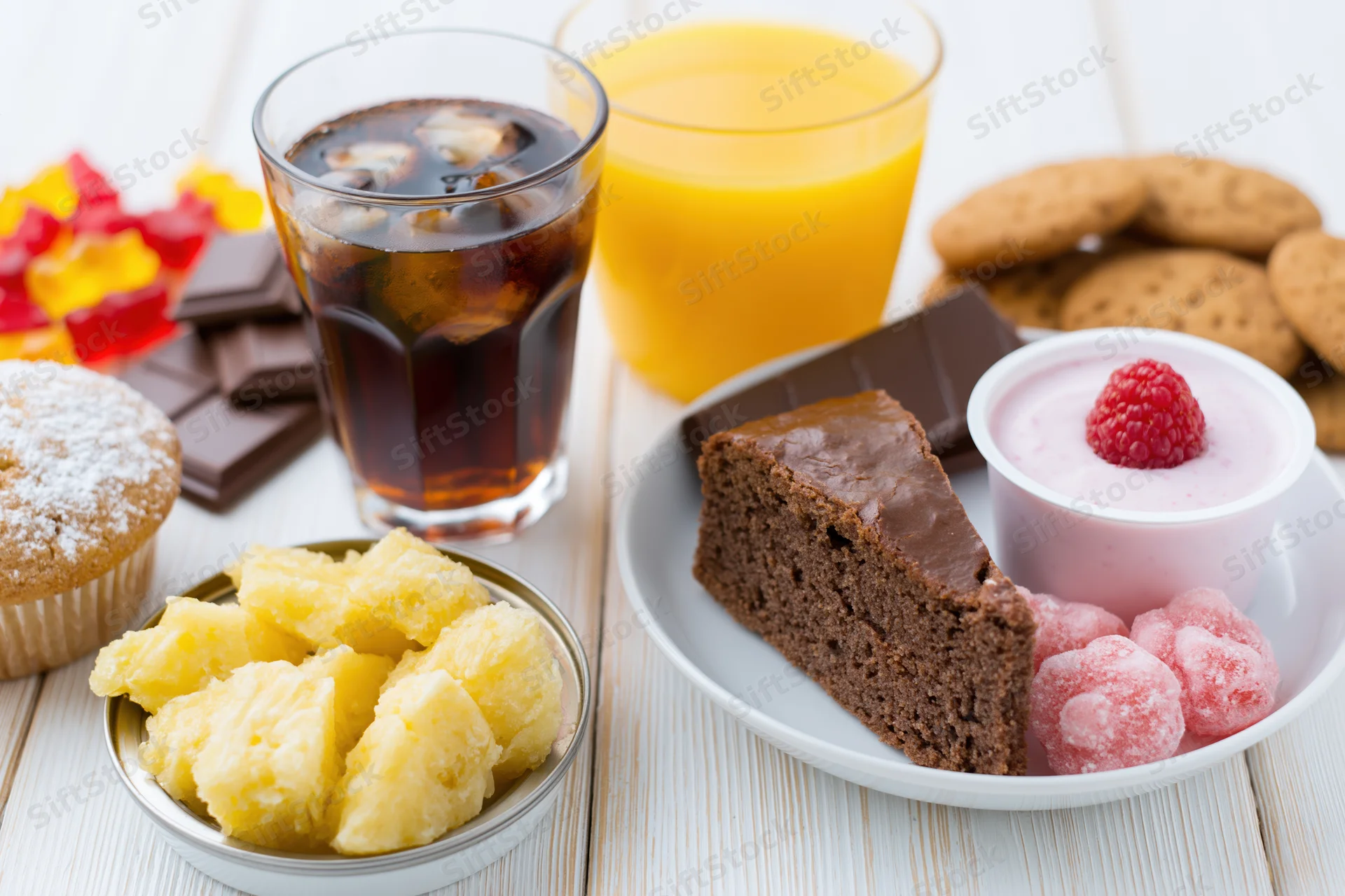 Assorted sugary foods and drinks arranged on a white painted wooden table