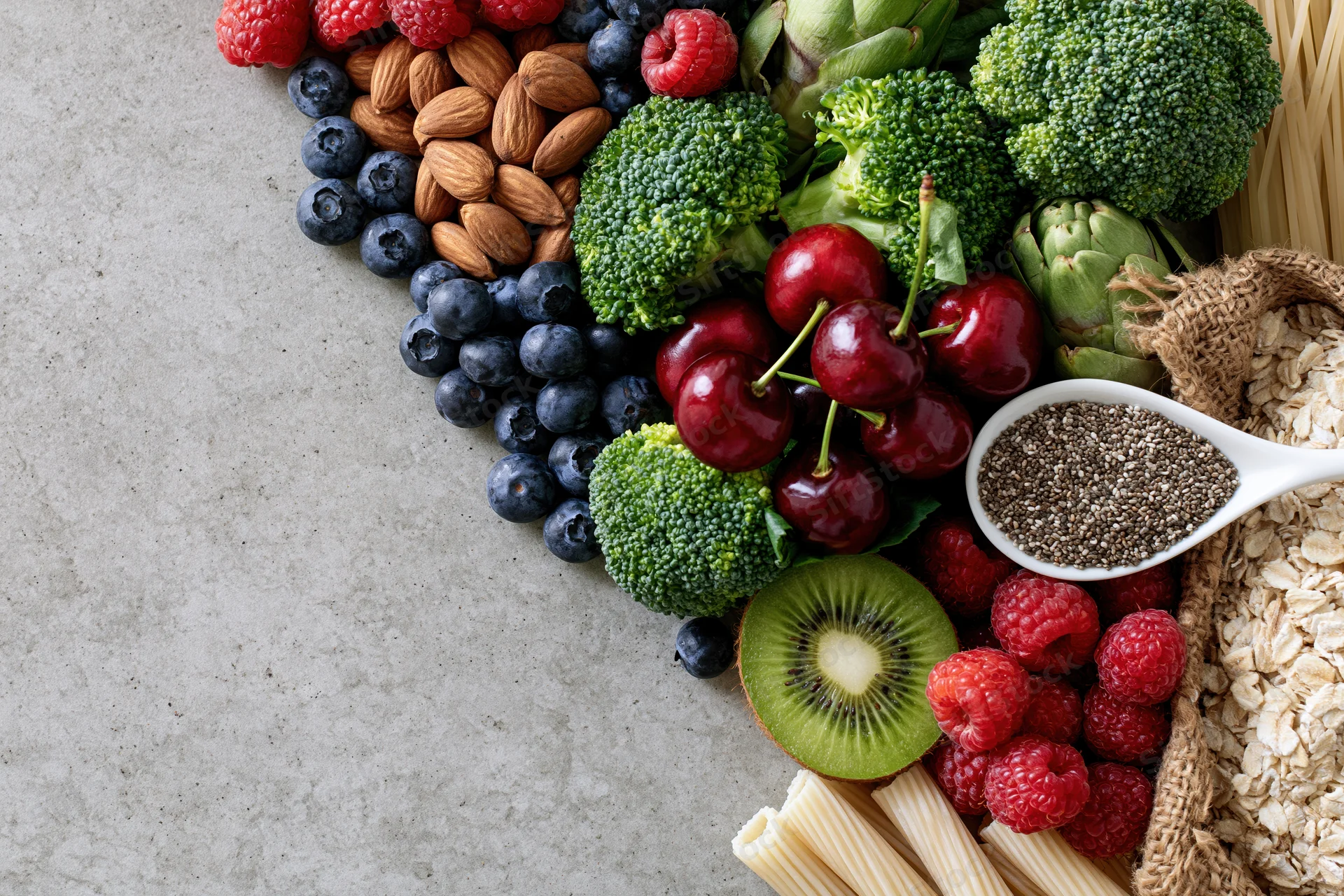 Assorted whole foods arranged diagonally on a countertop with copyspace