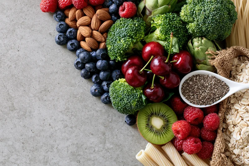 Assorted whole foods arranged diagonally on a countertop with copyspace