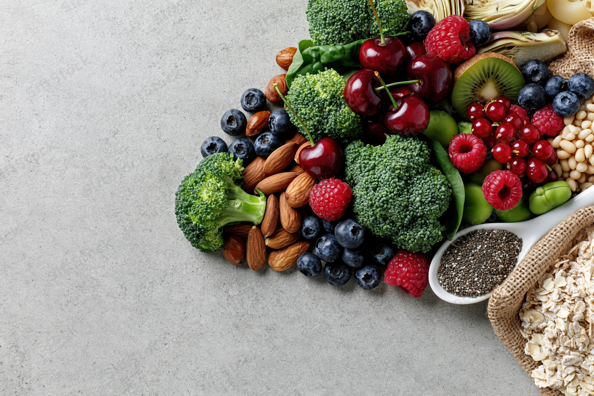 Assorted whole foods arranged diagonally on a countertop with copyspace