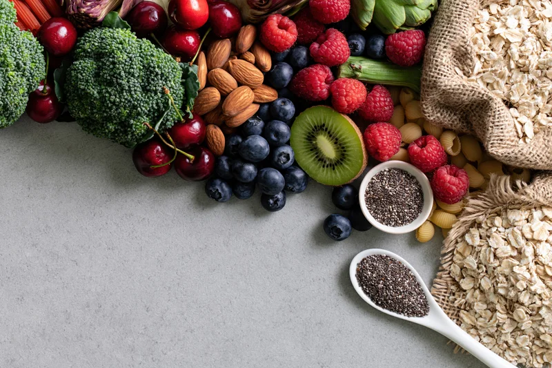 Assorted whole foods arranged diagonally on gray surface with copyspace