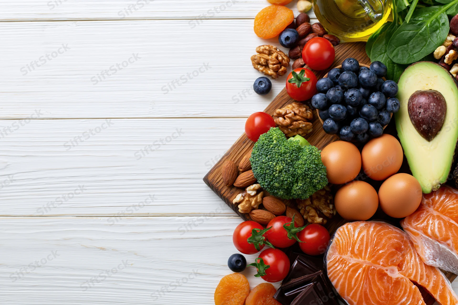 Healthy whole foods arranged on wooden board with white background and copyspace