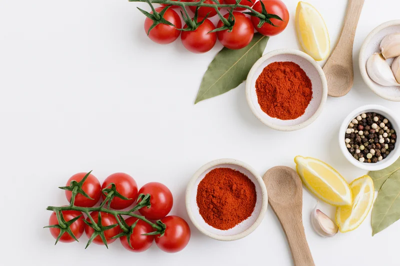 Fresh cooking ingredients arranged in a flat lay border frame on white surface