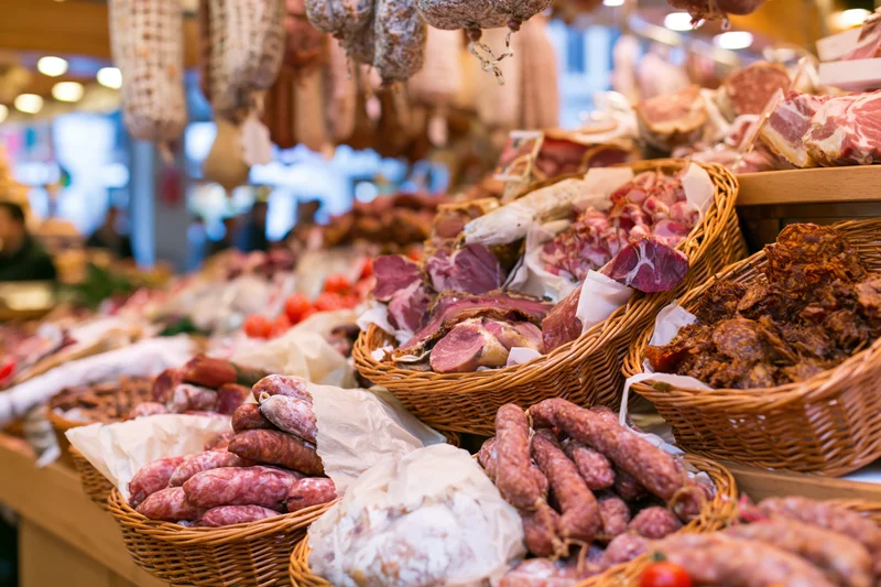 Cured meats displayed in wicker baskets at a european market stall