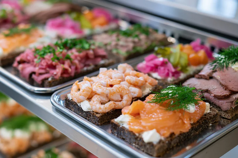Danish openfaced sandwiches smorrebrod arranged on metal trays in a buffet display