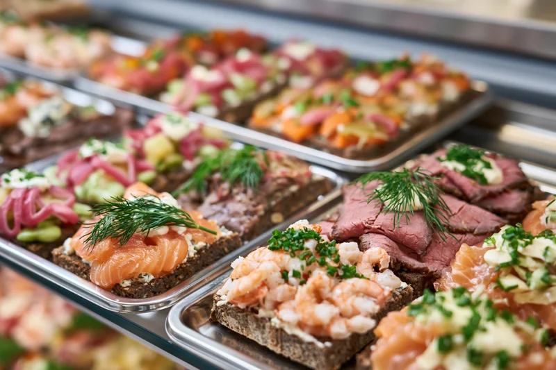 Danish openfaced sandwiches smorrebrod arranged on silver trays in a restaurant display