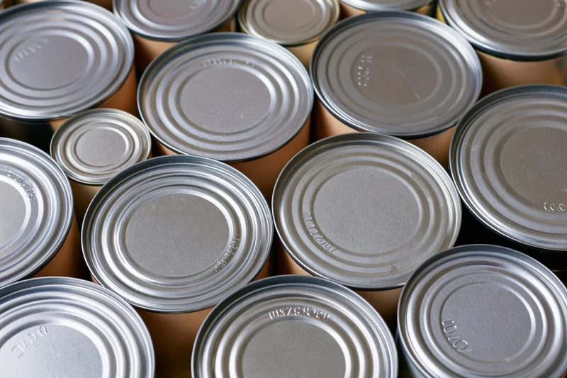 Metal food cans arranged tightly together in a storage setting