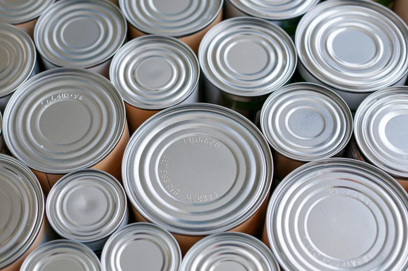 Close-up of metal food cans arranged tightly together in a storage setting
