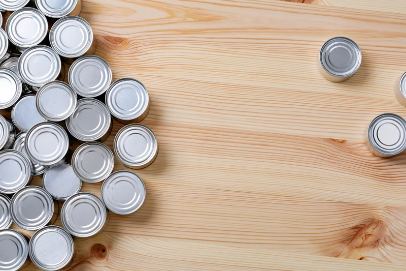 Silver tin cans grouped on a wooden table surface