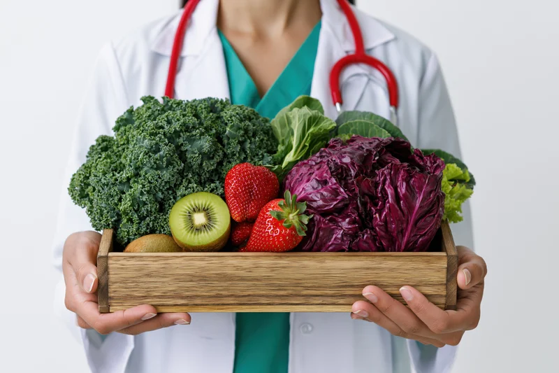 Female doctor holding wooden tray of fresh vegetables and fruit in lab coat