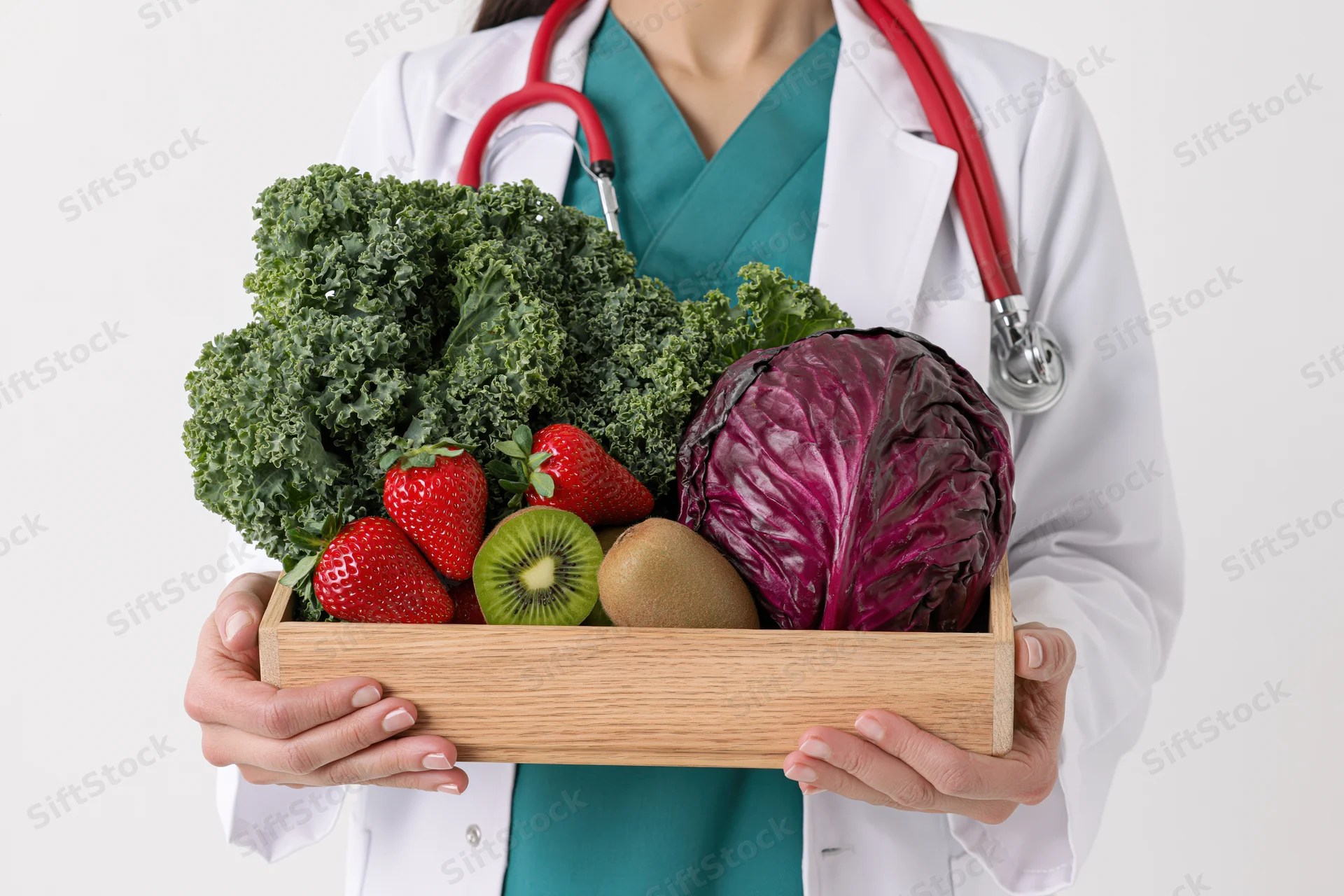 Female doctor holding wooden tray with fresh vegetables and fruit