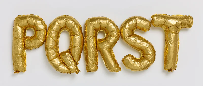Gold mylar foil letter balloons spelling P Q R S T arranged in a row on a white background