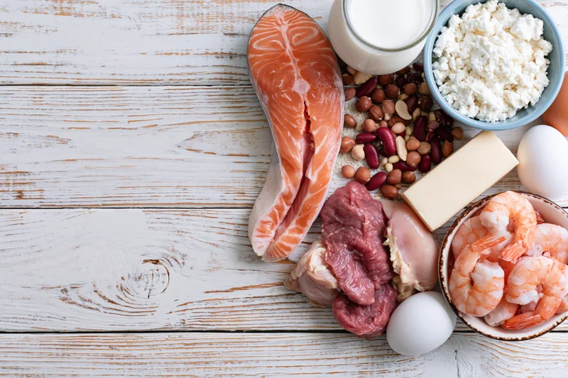 High-protein foods arranged on a whitewashed wooden table in flat lay view