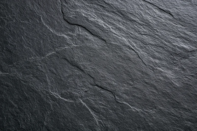 Close-up of dark slate stone surface with natural cracks and texture