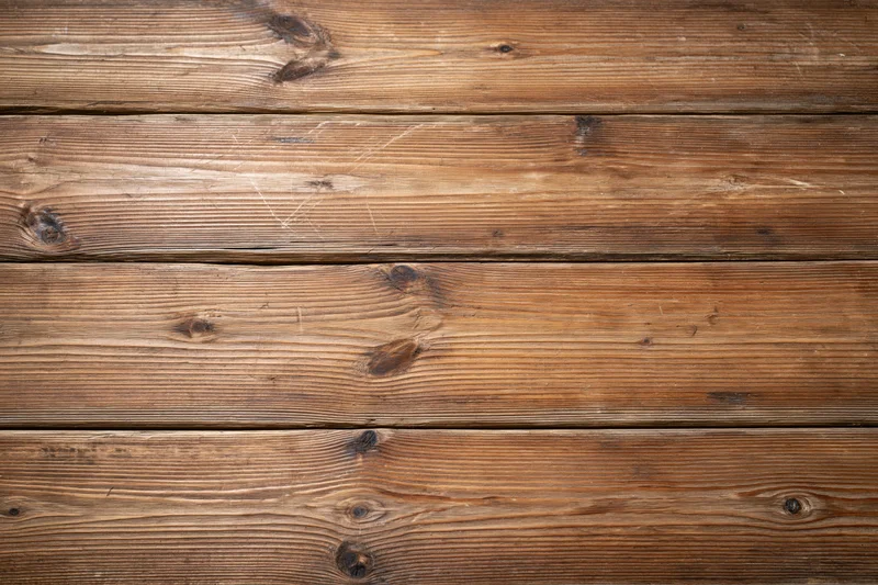 Horizontal wooden planks forming a textured surface with visible grain and knots