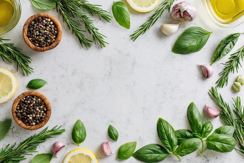 Fresh herbs and ingredients arranged in a flat lay on a marble surface with copyspace