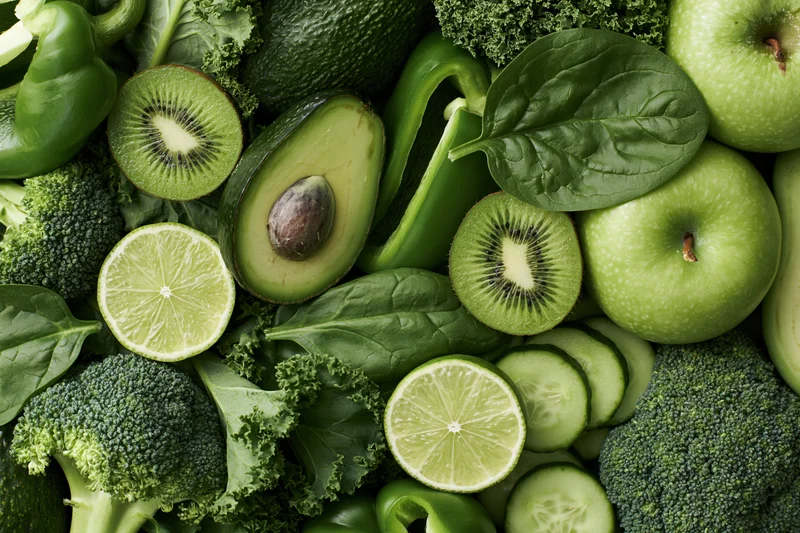 Assorted green fruits and vegetables arranged in a flat lay composition