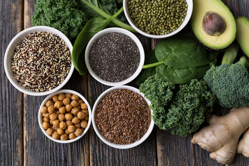 Assorted superfoods arranged in bowls and on a dark wooden surface