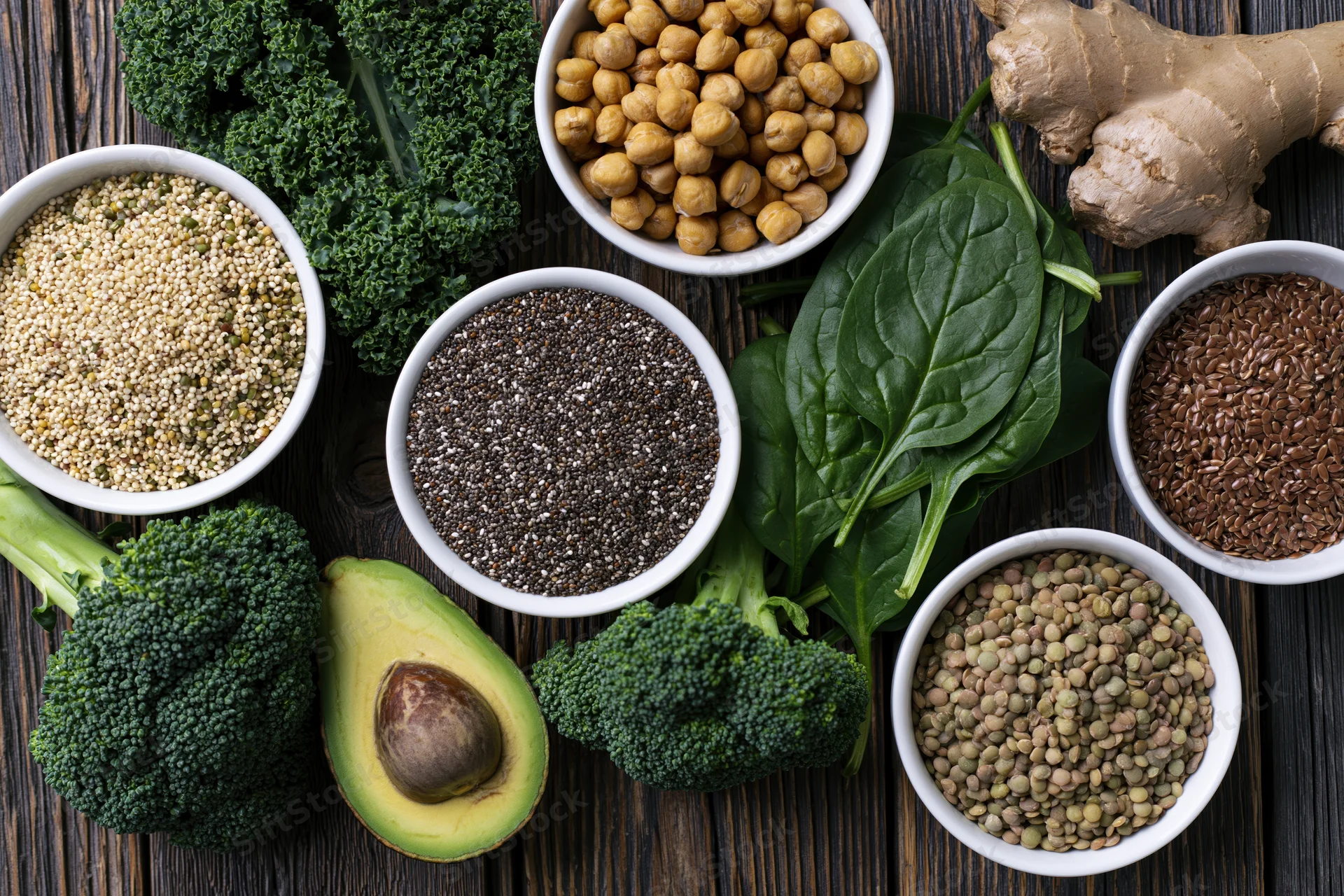 Assorted superfoods arranged in bowls and piles on dark wooden surface
