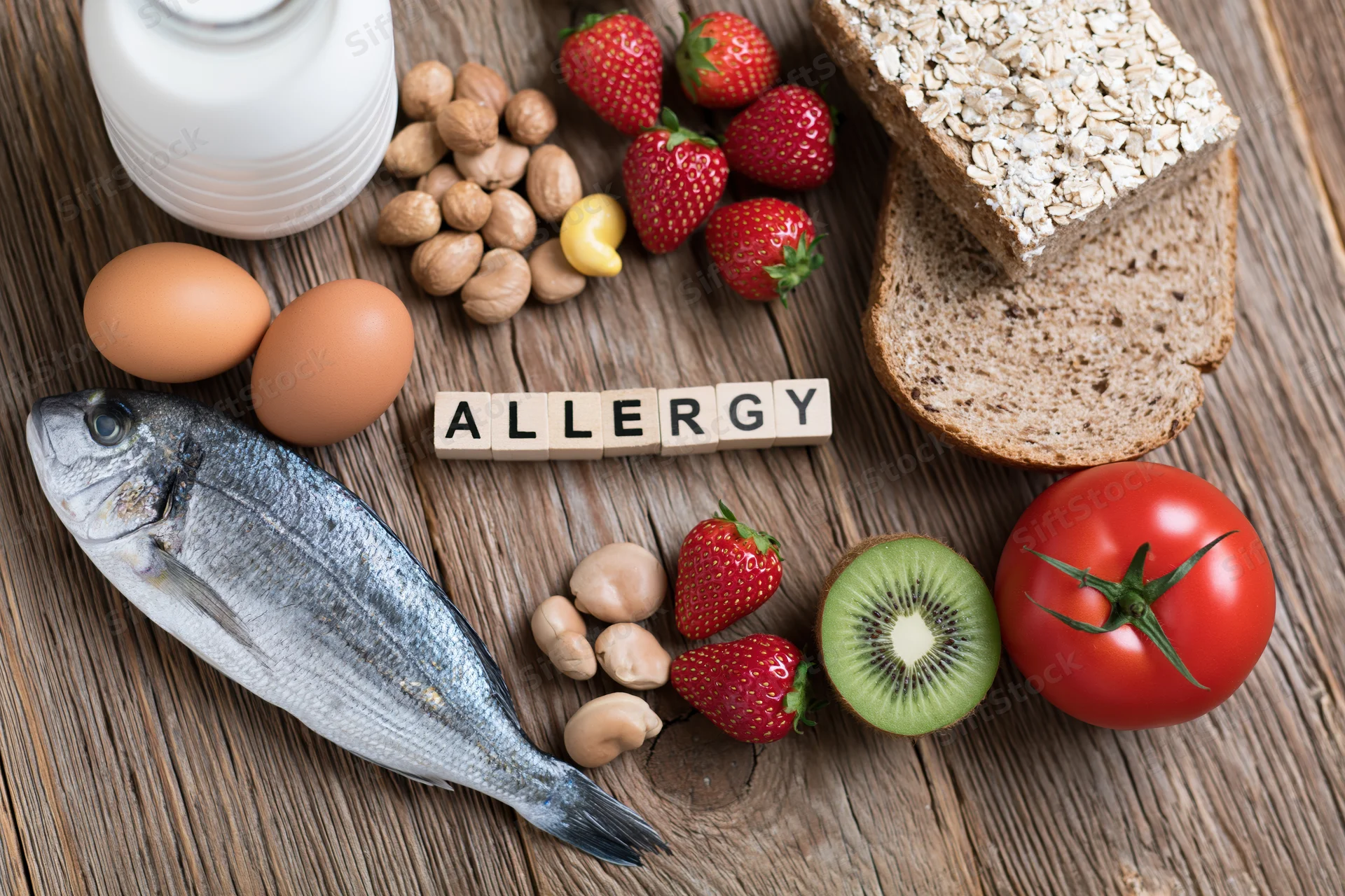 Common food allergens arranged on a rustic wooden surface with wooden blocks spelling allergy
