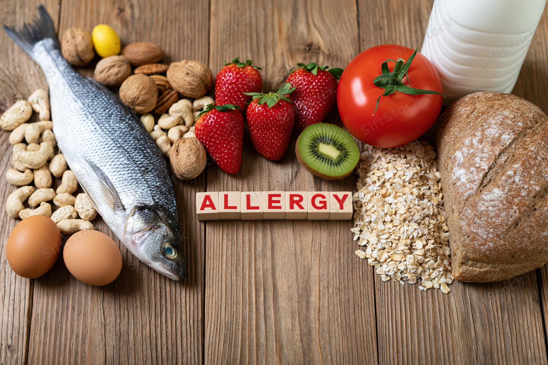 Common food allergens arranged on a rustic wooden surface with wooden blocks spelling allergy