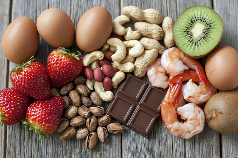 Common food allergens arranged in a flat lay on a weathered wooden surface