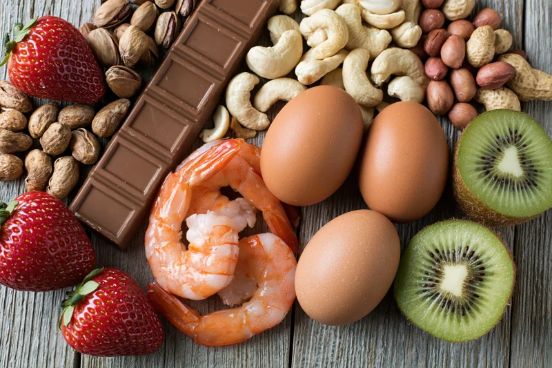 Common food allergens arranged in a flat lay on weathered wood surface
