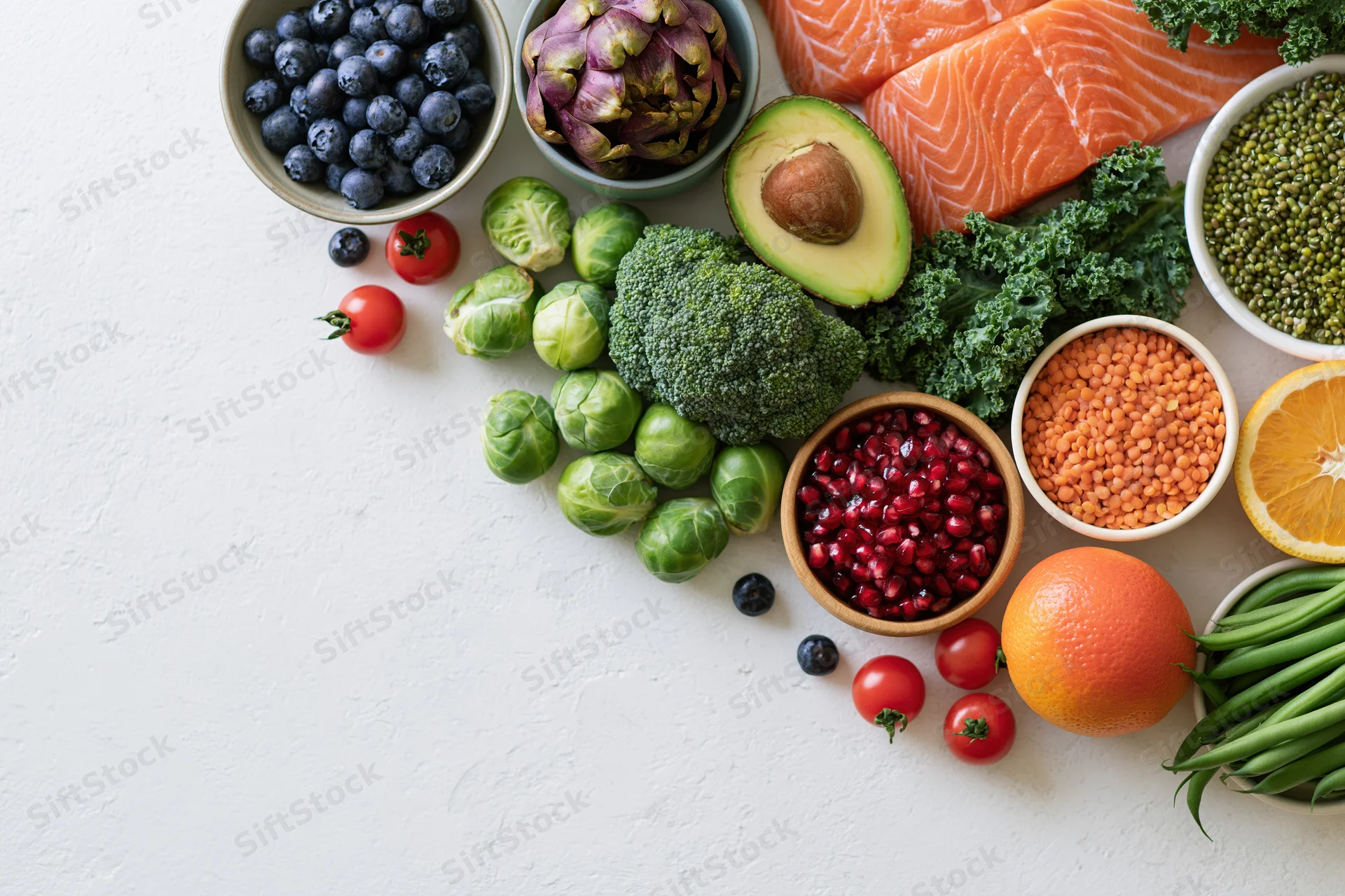Fresh healthy foods arranged in a flat lay on a white textured surface