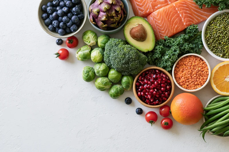 Fresh healthy foods arranged in a flat lay on a white textured surface