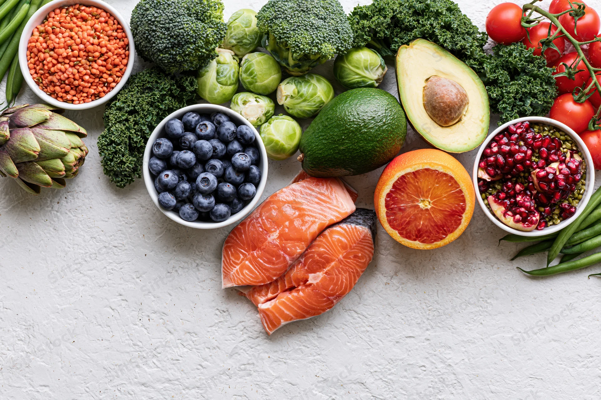 Fresh healthy foods arranged in a flat lay on a white textured surface