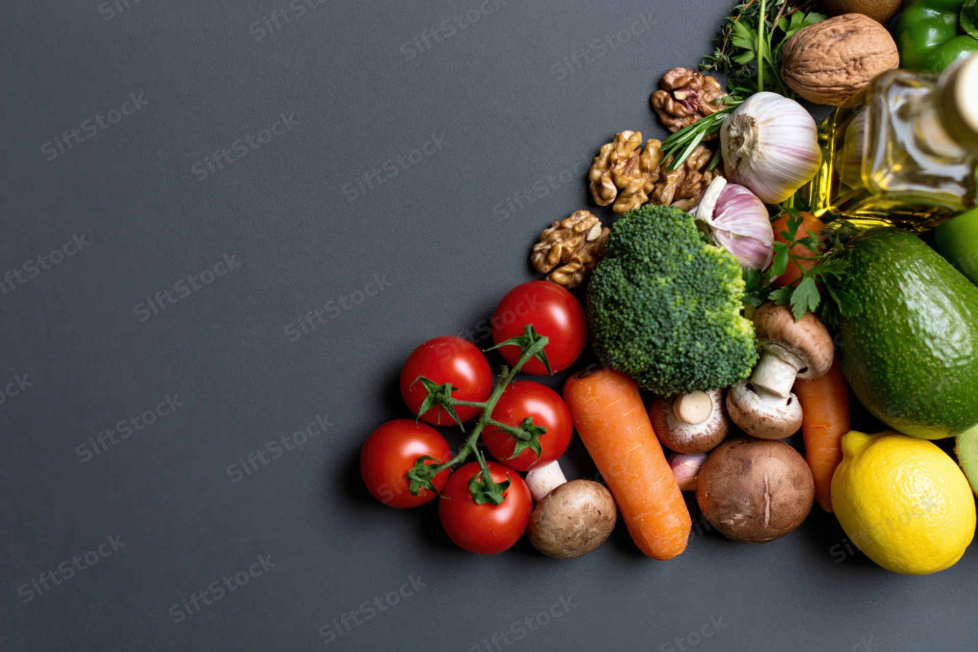Fresh vegetables fruits and nuts arranged in a corner on dark surface