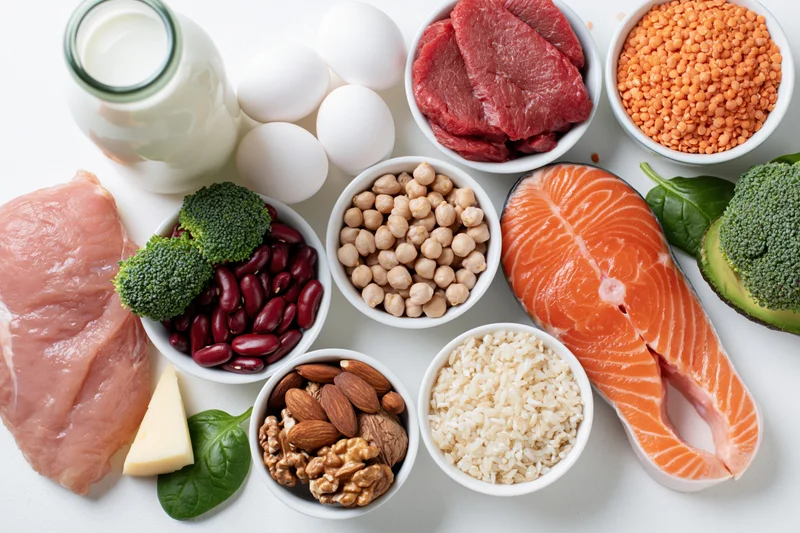 High-protein foods arranged in bowls and portions on a white surface