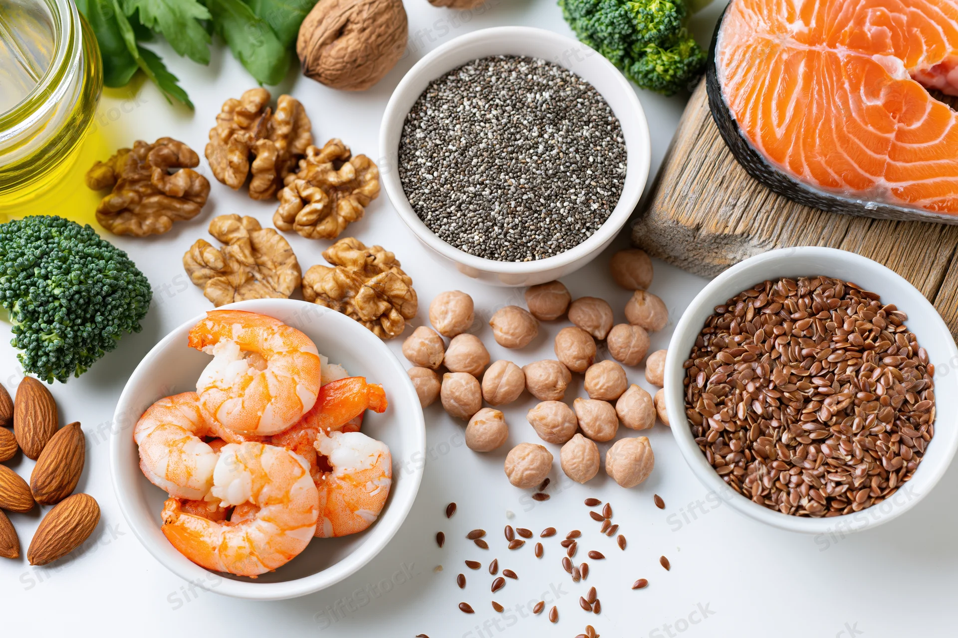 Omega3 rich foods arranged in bowls and piles on white surface